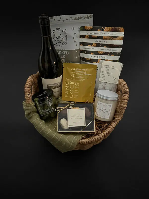 Side view of cozy gift basket featuring grounding candle, wine, and gourmet treats