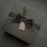 Luxe black gift box with satin ribbon and handwritten notecard – Muse Baskets & Co. Thinking of You collection.