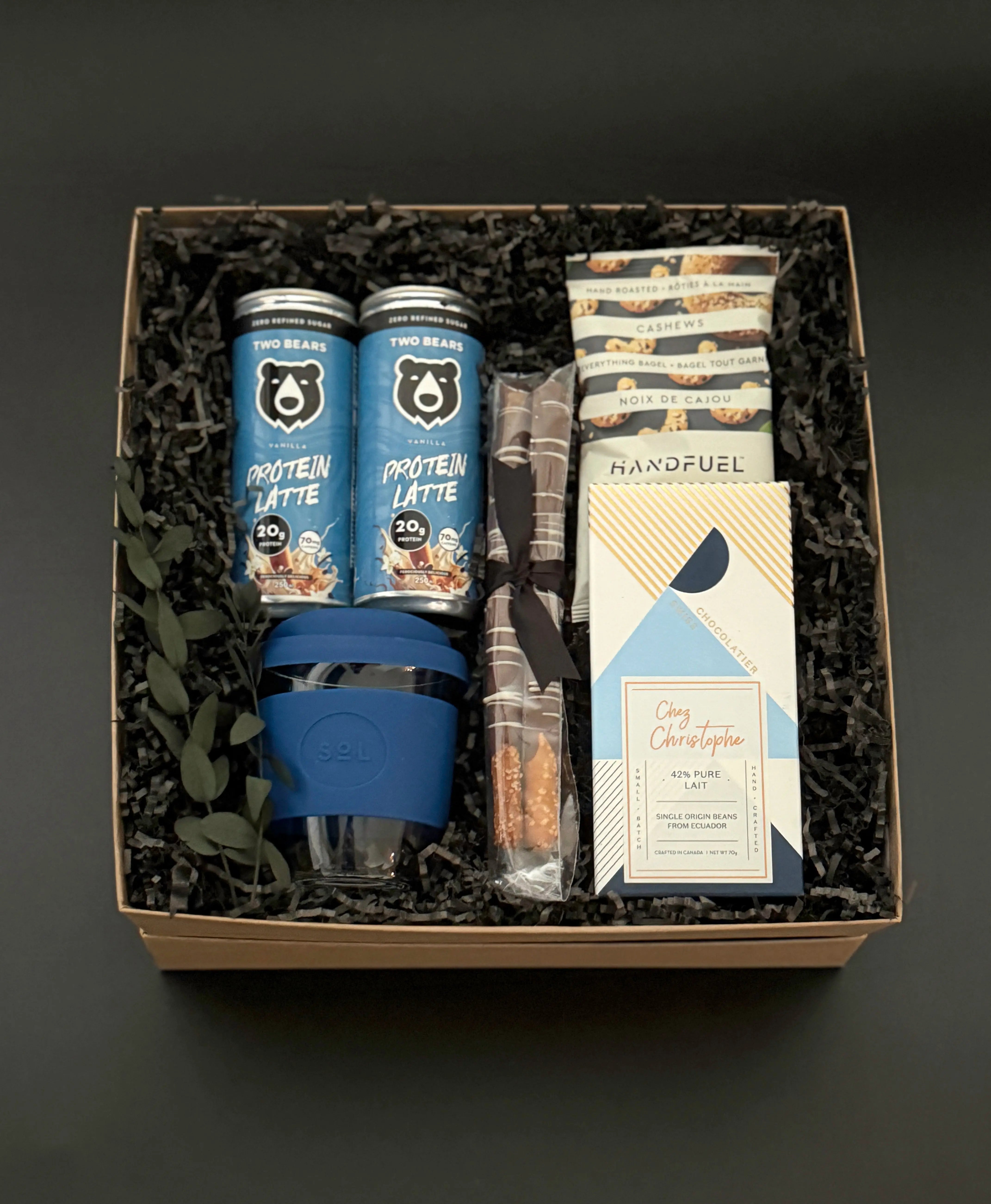 The Reset wellness gift box for men featuring protein lattes, cashews, chocolate, pretzel rods, and reusable travel cup – Muse Baskets & Co.