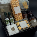 Curated artisan housewarming gift box featuring gourmet crackers, chocolates, infused olive oil, balsamic, and preserves.