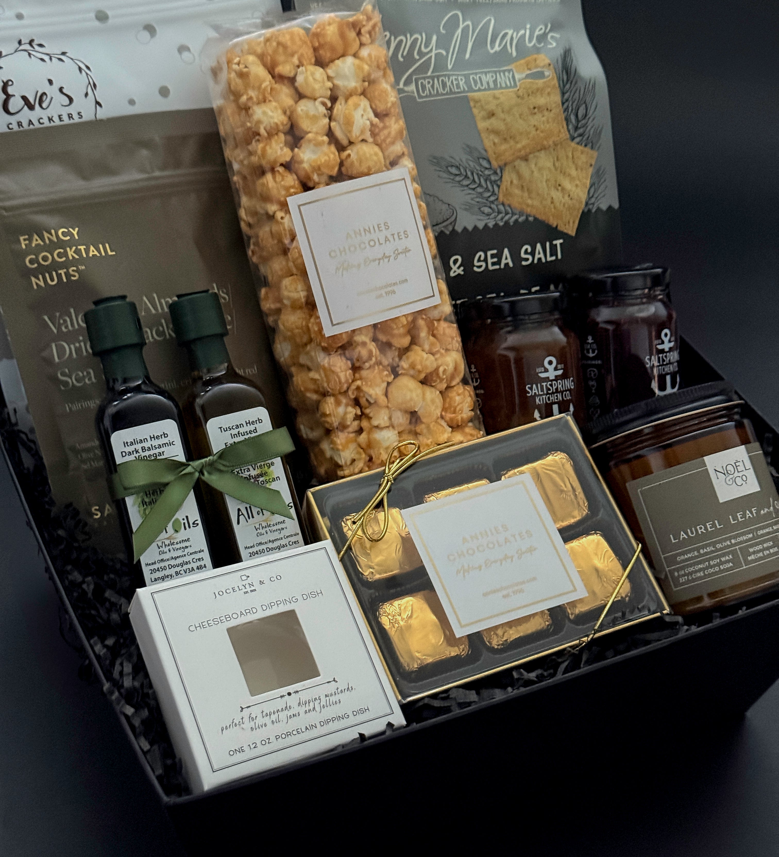Curated artisan housewarming gift box featuring gourmet crackers, chocolates, infused olive oil, balsamic, and preserves.