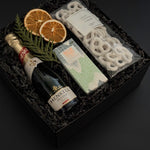 Étoile holiday gift box with sparkling wine, artisan chocolate, pretzels, and festive citrus accents.