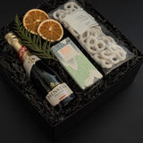 Étoile holiday gift box with sparkling wine, artisan chocolate, pretzels, and festive citrus accents.
