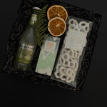 Holiday gift box with Fever-Tree ginger beer, chocolate, white chocolate pretzels and seasonal greenery