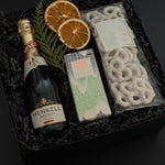 Corporate holiday gift box featuring Henkell sparkling wine, chocolate bar, and white chocolate pretzels.