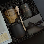 Close-up of Solenne’s curated contents — golden honey, stoneware mug, gourmet coffee, and maple syrup styled elegantly.