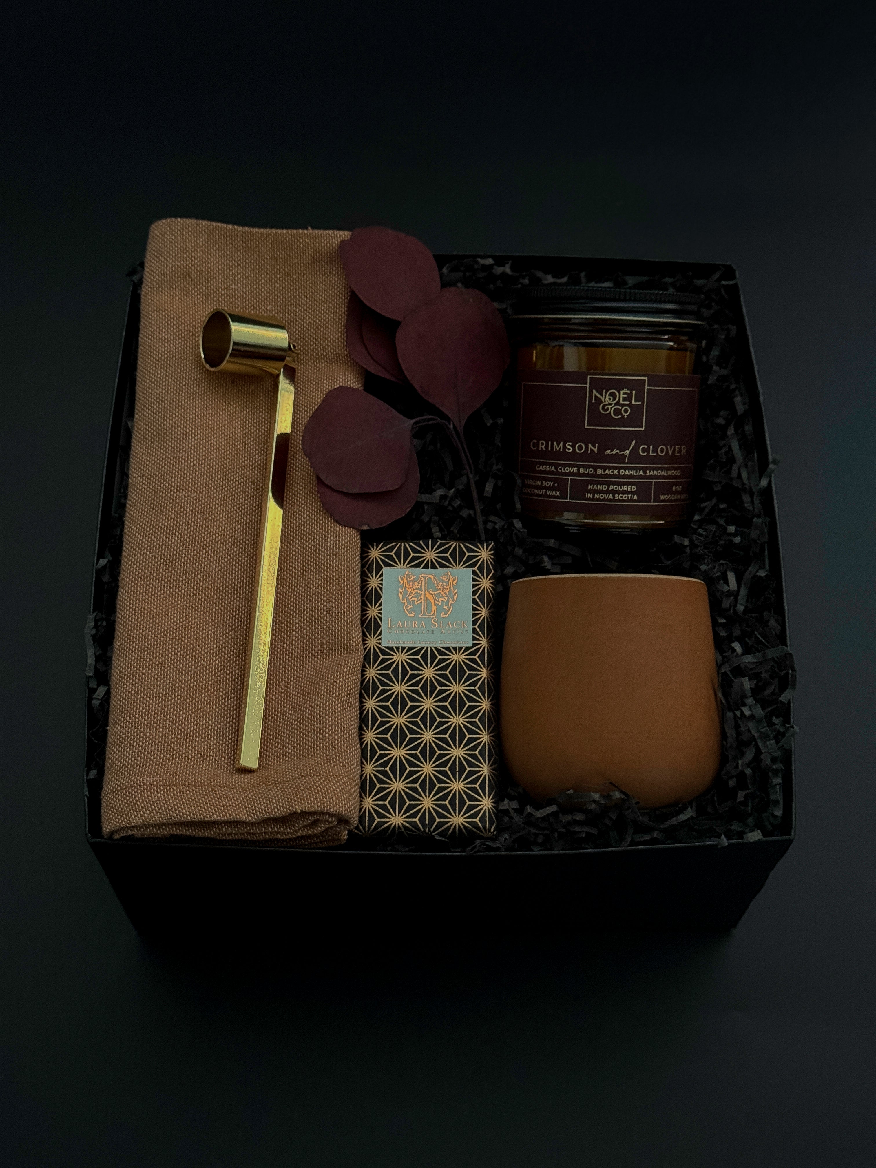 Nocturne holiday gift box with artisan candle, chocolate, stoneware cup, and linen napkin.