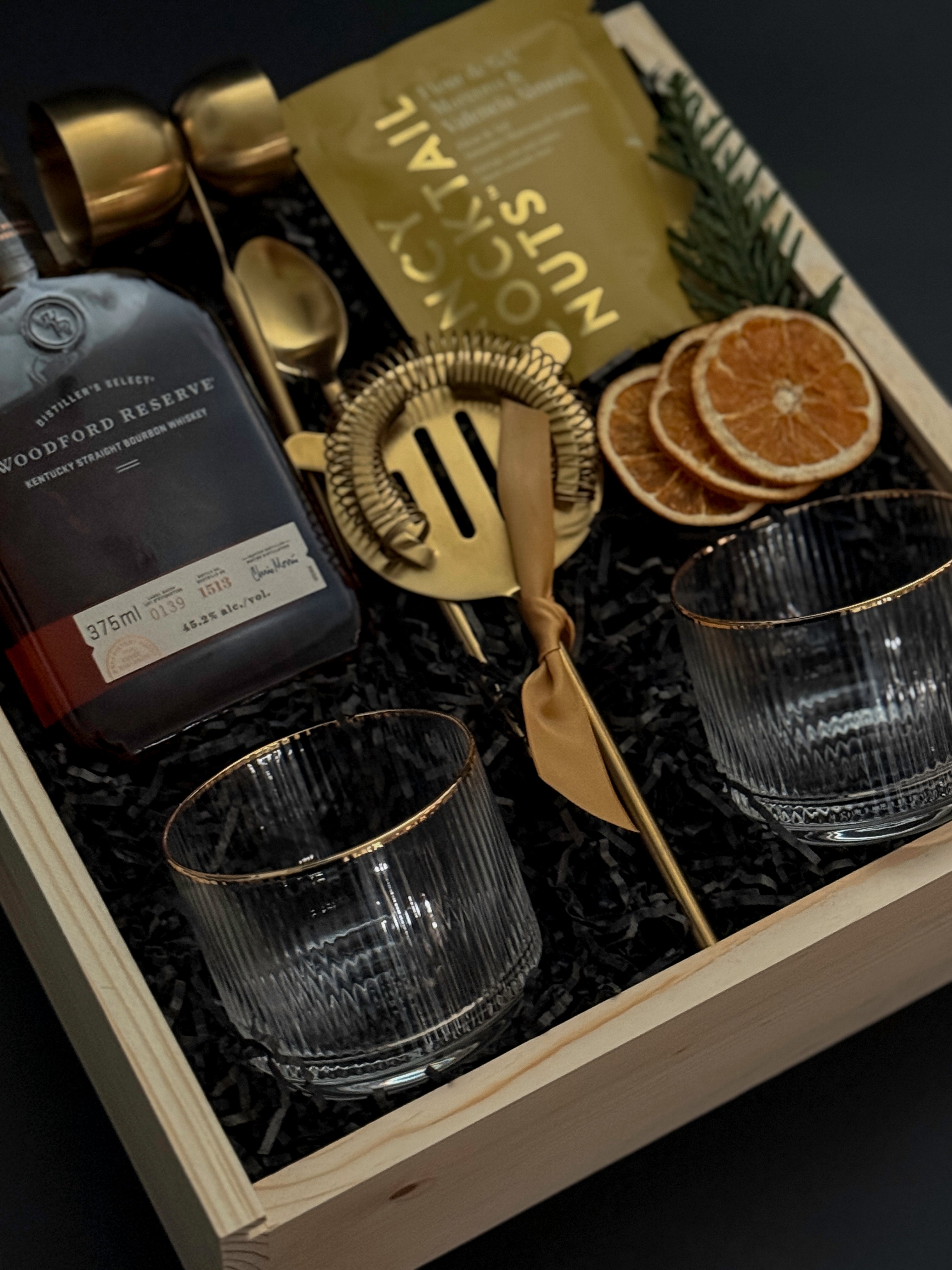 Corporate whiskey gift box featuring bourbon, Viski glasses, almonds, and festive details.