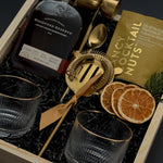 Holiday whiskey gift box with Woodford Reserve, gold tools, almonds, and mandarins