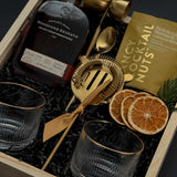 Holiday whiskey gift box with Woodford Reserve, gold tools, almonds, and mandarins
