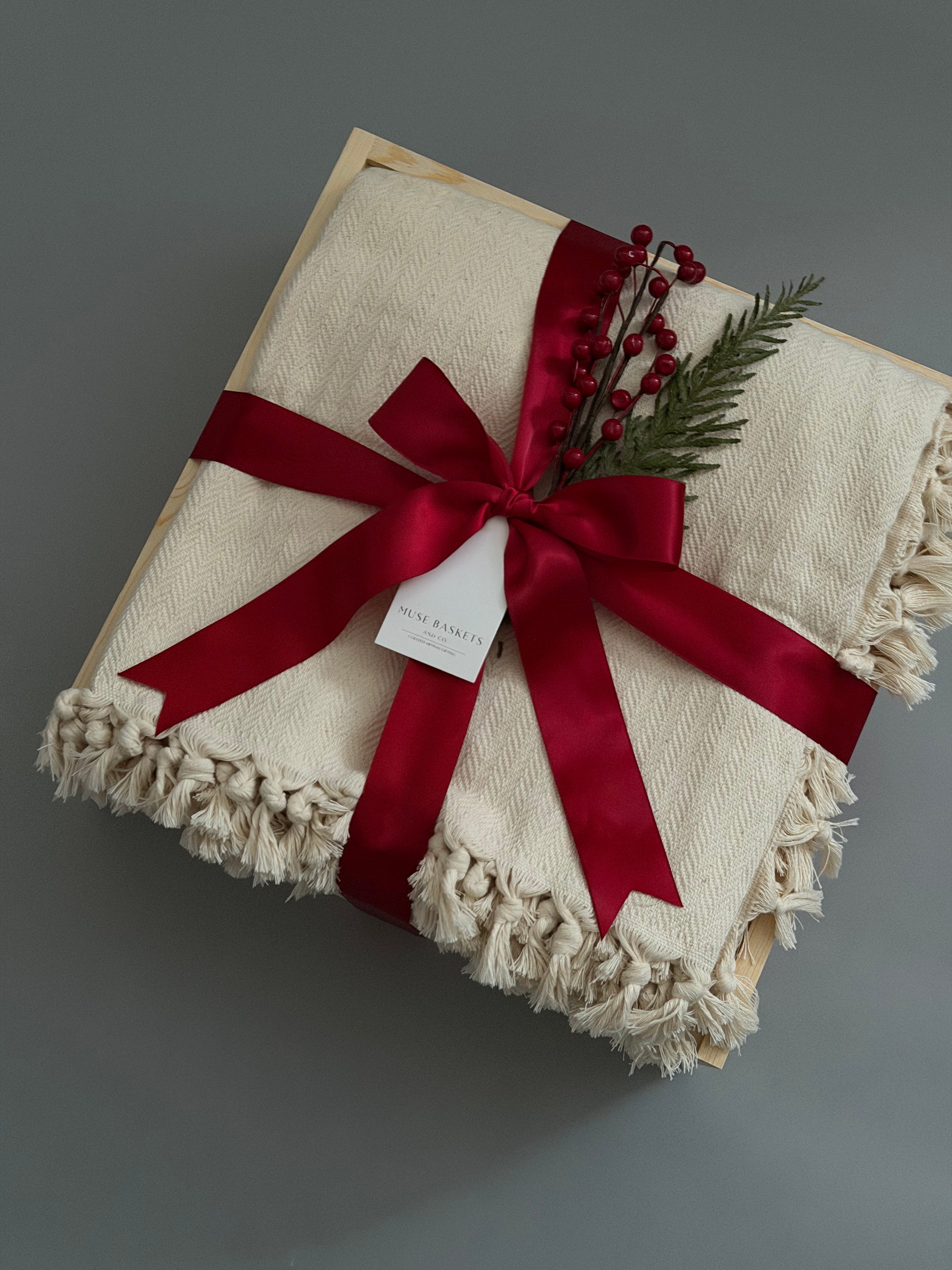 Closed gift box with cream blanket and holiday decorations, perfect for  corporate clients and colleagues.