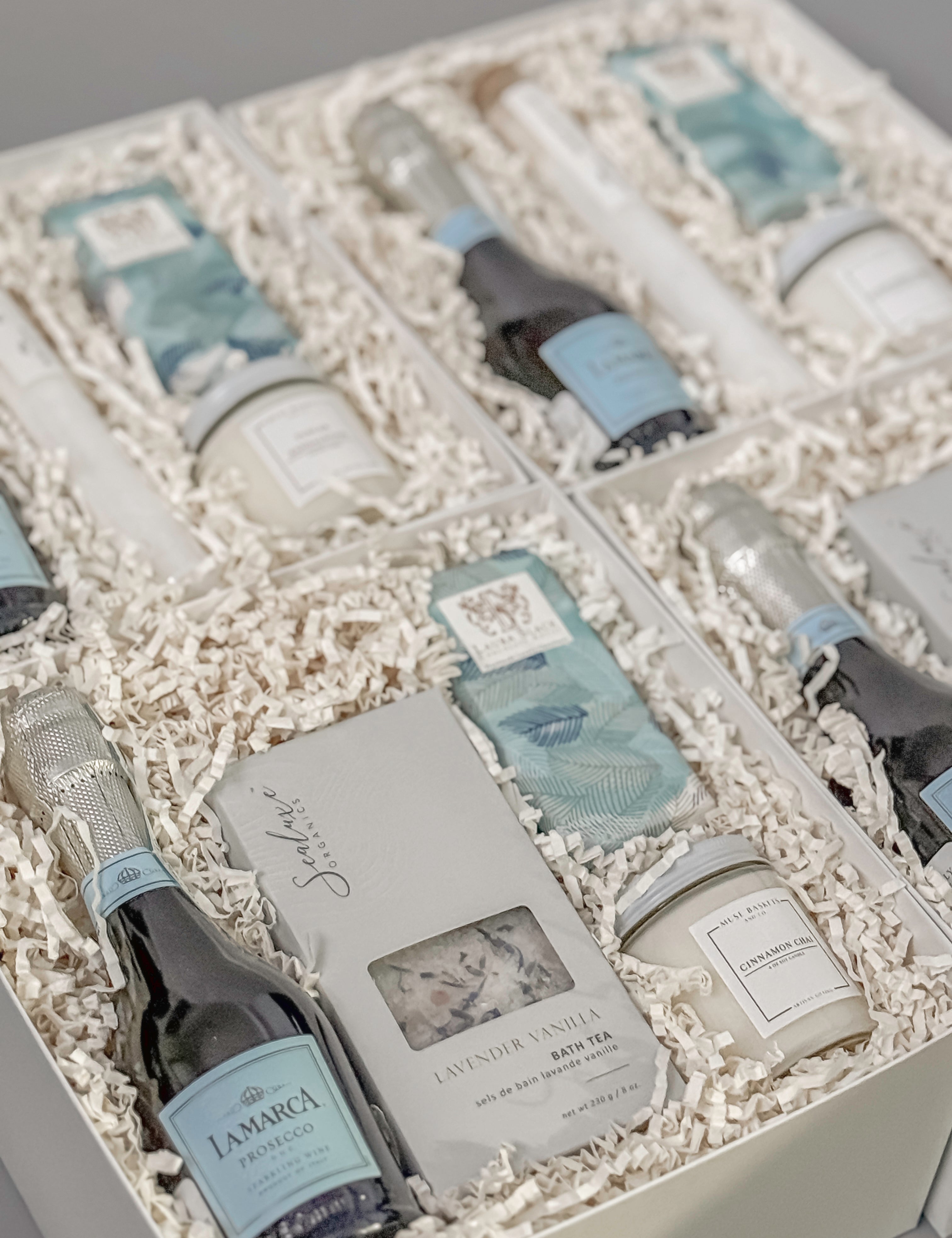 Elegant gift boxes curated by Muse Baskets and Co., featuring La Marca Prosecco, artisan bath tea, gourmet chocolate, and hand-poured candles — ideal for luxury corporate gifting and client appreciation.