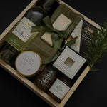 Charcuterie-inspired holiday gift box with wine, cheese, preserves, chocolate, and festive greenery — an elevated gift for corporate clients and office teams.