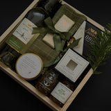 Charcuterie-inspired holiday gift box with wine, cheese, preserves, chocolate, and festive greenery — an elevated gift for corporate clients and office teams.