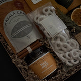 Wellness gift set with loose leaf chai tea, biscuits, socks and gourmet jam in kraft box.
