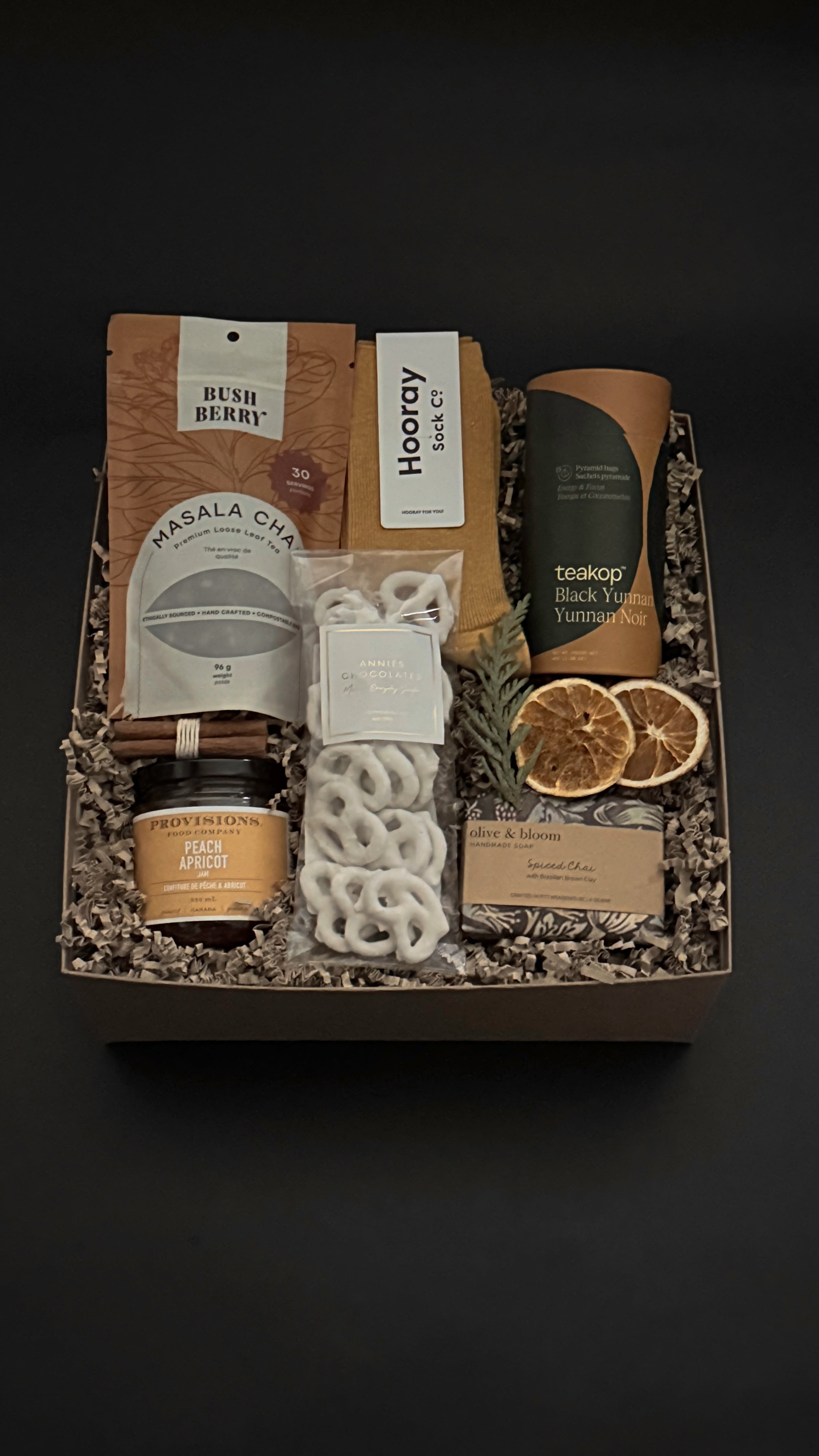 Curated winter tea gift box with chai, cozy socks, artisan chocolate and pretzels by Muse Baskets and Co.
