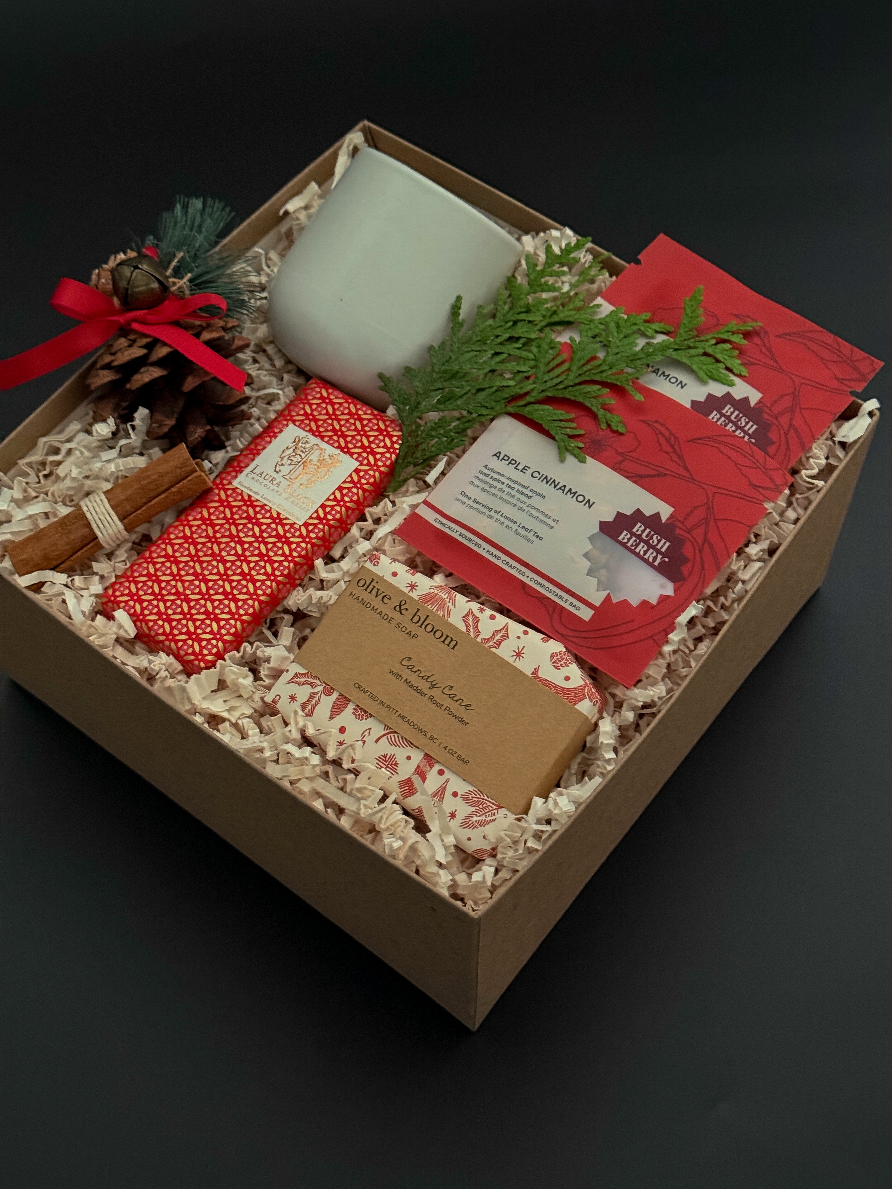 Corporate holiday gift box with stoneware cup, candy cane soap, chocolate, and greenery.