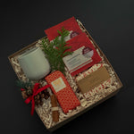 Executive holiday gift box with artisan chocolate, soap, cup, and festive ribbon.