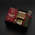 Gourmet gift set with cookies, tea, and other items on a dark background