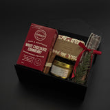 Gourmet gift set with cookies, tea, and other items on a dark background