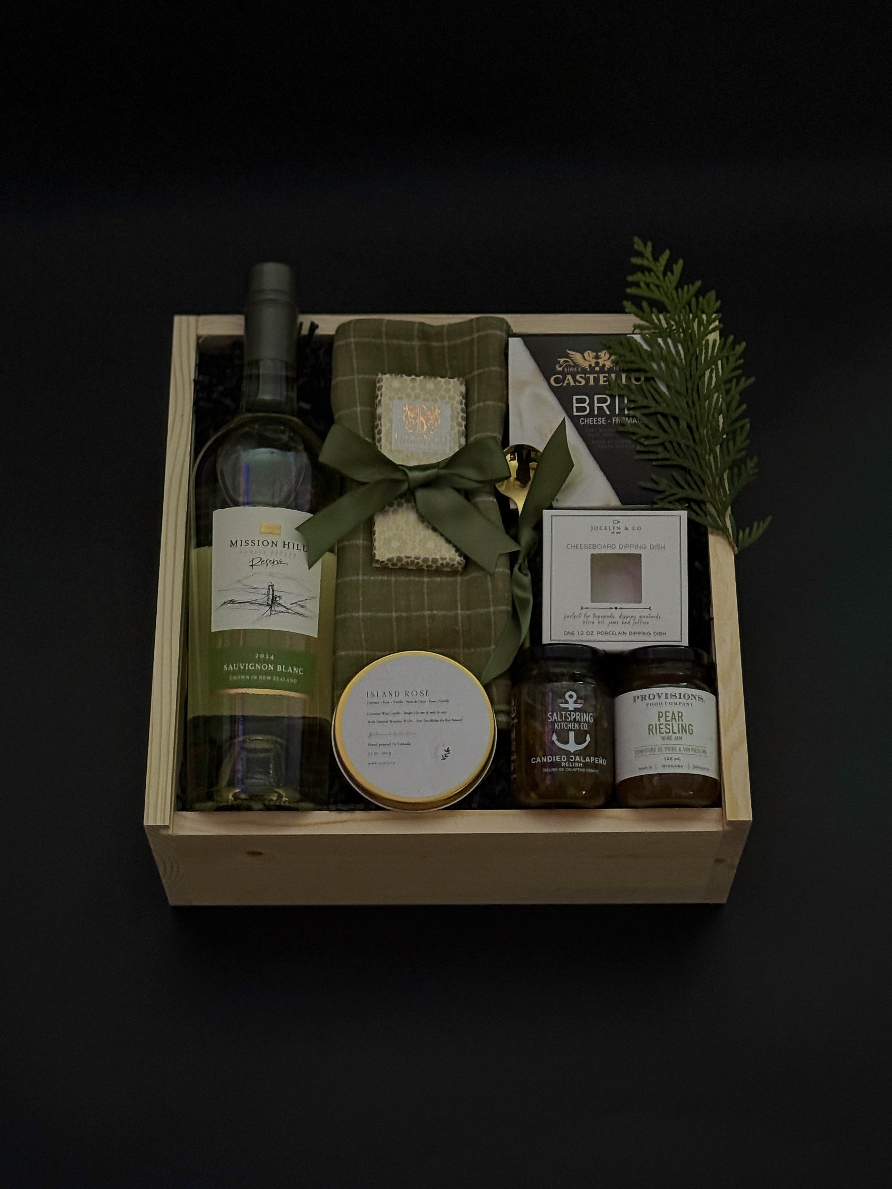 Elegant holiday wine gift box with Mission Hill Sauvignon Blanc, Brie, artisan preserves, chocolate, and charcuterie essentials. Perfect for corporate and client gifting.