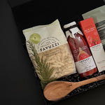 Favuzzi food products including a wooden spoon on a dark background