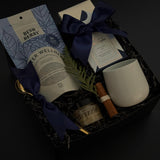 Sanctuary in Winter gift box featuring winter wellness tea, milk chocolate bar, honey, stoneware mug, and seasonal accents in a black bo