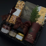 Holiday gift box with sweet and savoury Canadian artisan treats in black gift box with ribbon.