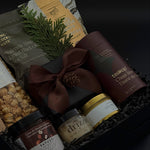 Elegant client appreciation gift box featuring sweet and savoury artisan foods and a gold tin candle.