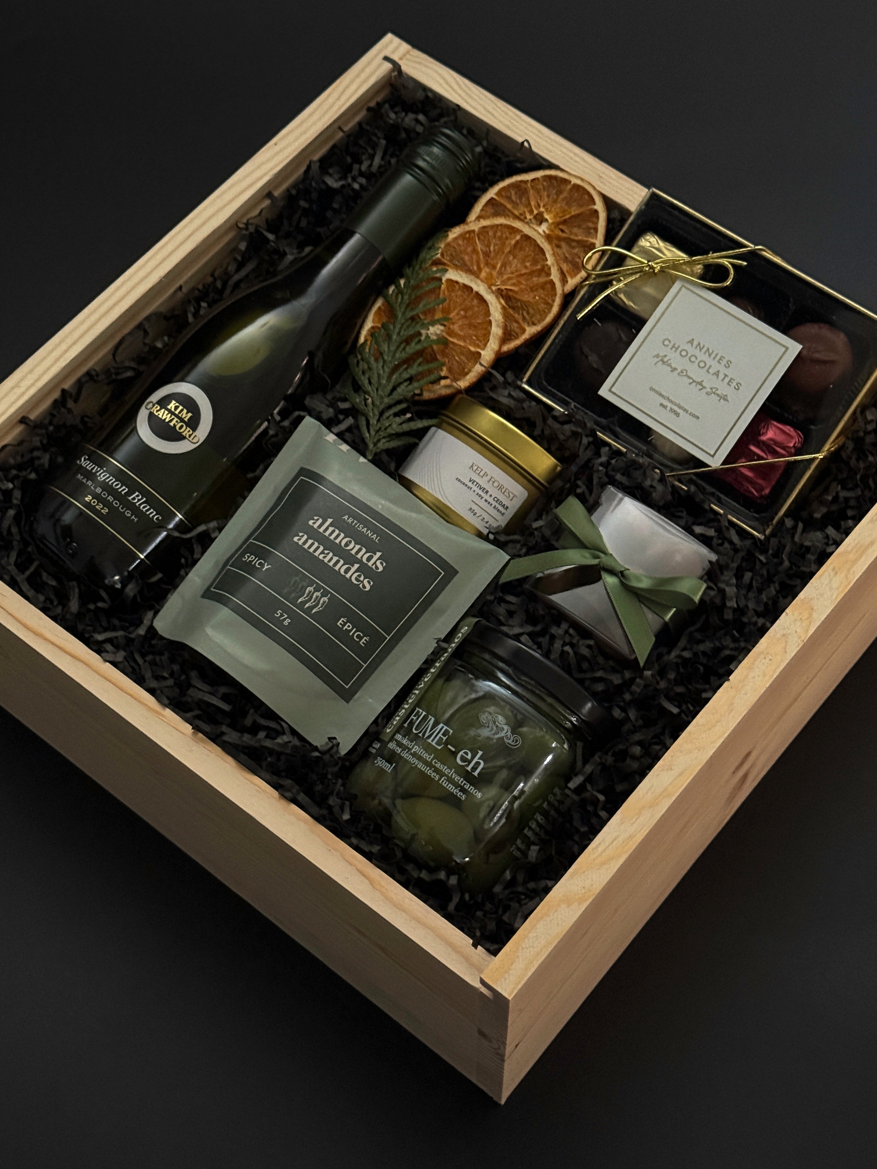 Client appreciation gift box with wine, gourmet almonds, chocolates, and festive presentation.