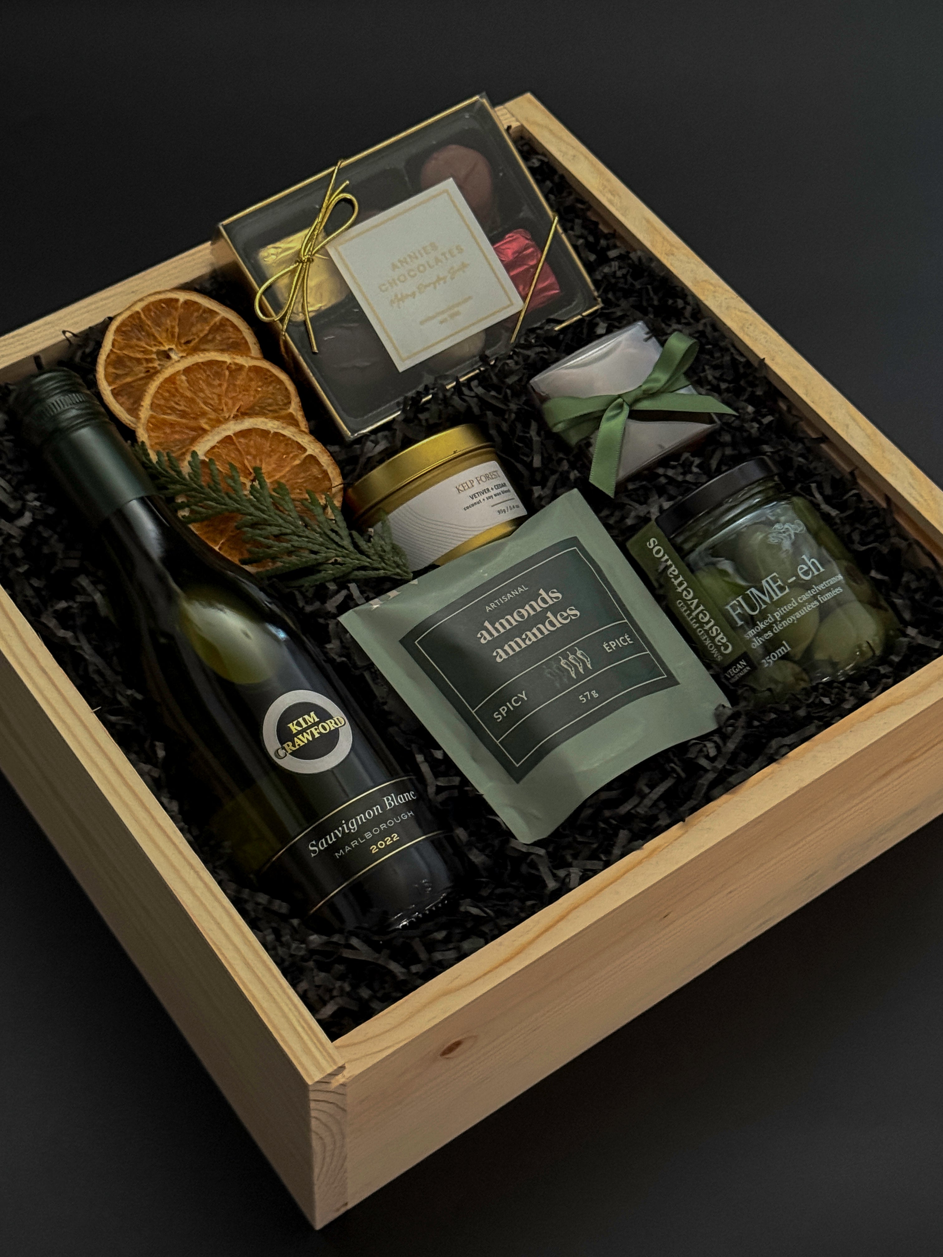 Curated gourmet gift box featuring Sauvignon Blanc, chocolates, almonds, and holiday details.