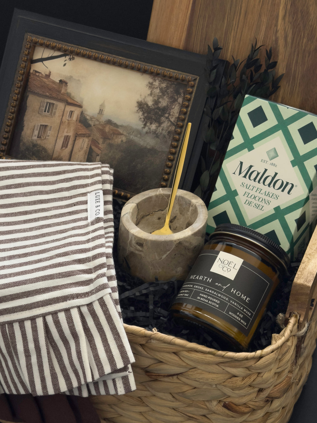 Woven housewarming gift basket with Canadian-made home accents, acacia serving board, Maldon salt, marble salt cellar and Hearth & Home candle by Muse Baskets and Co.