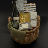 Grounded luxury gift basket with wine, candle, truffles, and savoury snacks in wicker basket