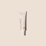 White tube of PAUME cream on a beige background