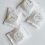 Aqua Studio shower steamer packets in Flower Temple, Hinoki, Menthol Eucalyptus, and Sweet Dreams scents, a self-care product featured in Muse Baskets and Co. gift baskets