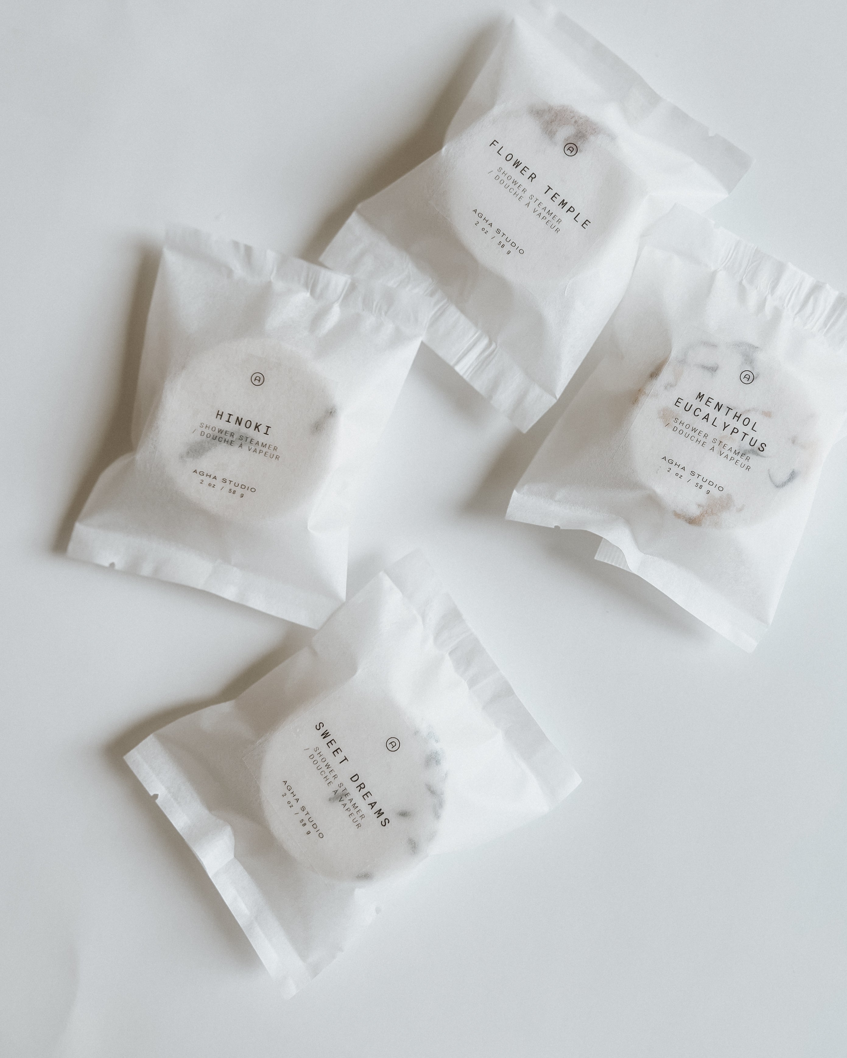 Aqua Studio shower steamer packets in Flower Temple, Hinoki, Menthol Eucalyptus, and Sweet Dreams scents, a self-care product featured in Muse Baskets and Co. gift baskets