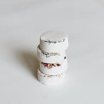 Close-up of stacked Aqua Studio shower steamers with dried floral accents, a self-care product featured in Muse Baskets and Co. gift baskets