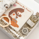 Gender-neutral baby gift for new parents by Muse Baskets and Co., presented in a signature white gift box with a swaddle, keepsake book and newborn essentials.
