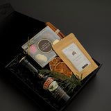 Corporate holiday gift box by Muse Baskets and Co. with Baileys, chocolate, hot chocolate, evergreen accents and satin ribbon for client appreciation.
