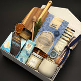 Fireside Provisions client appreciation gift by Muse Baskets and Co., with a soy candle, stoneware tea cup and chocolate in a Signature Pearl White gift box.