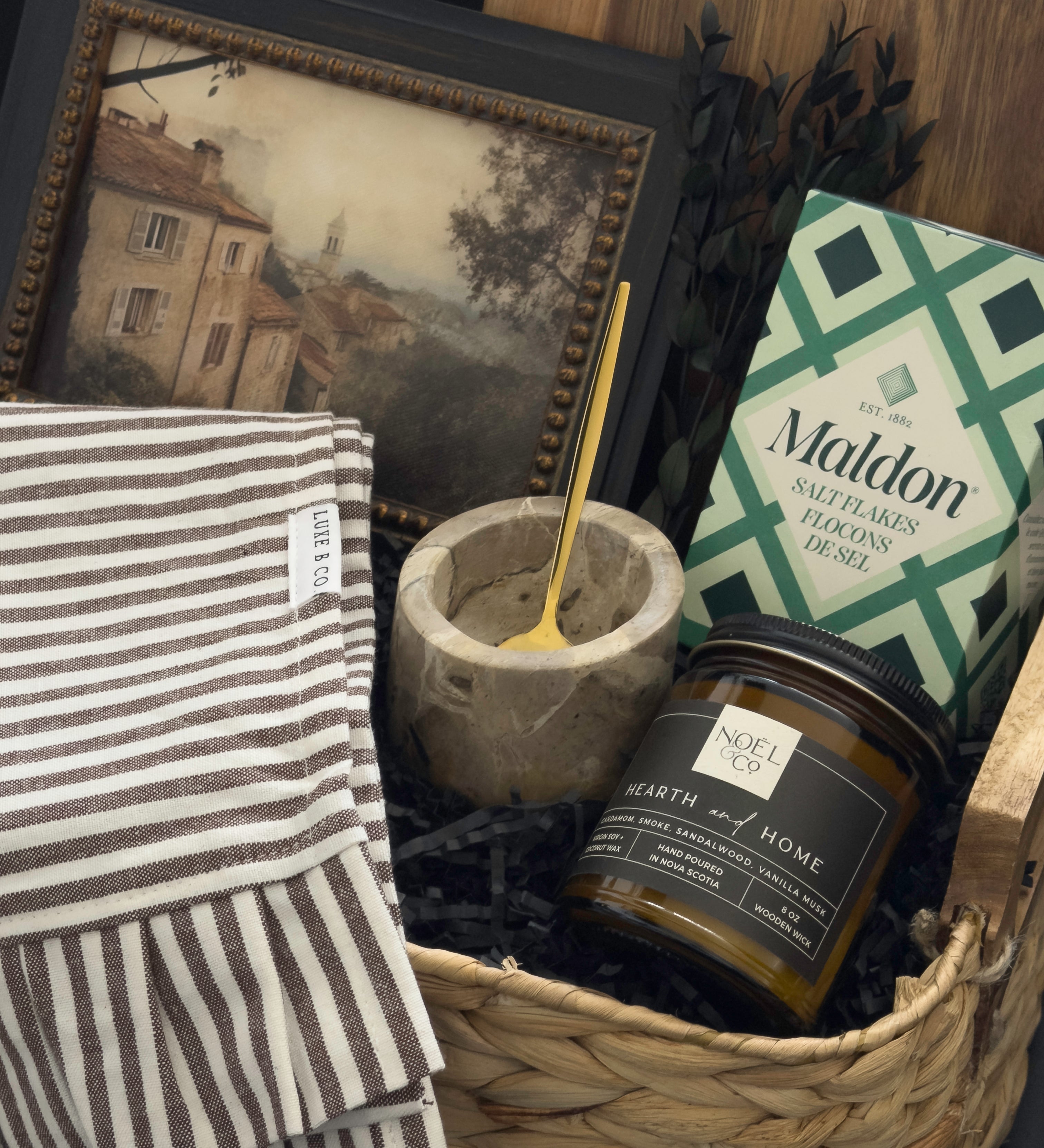 Woven housewarming gift basket with Canadian-made home accents, acacia serving board, Maldon salt, marble salt cellar and Hearth & Home candle by Muse Baskets and Co.