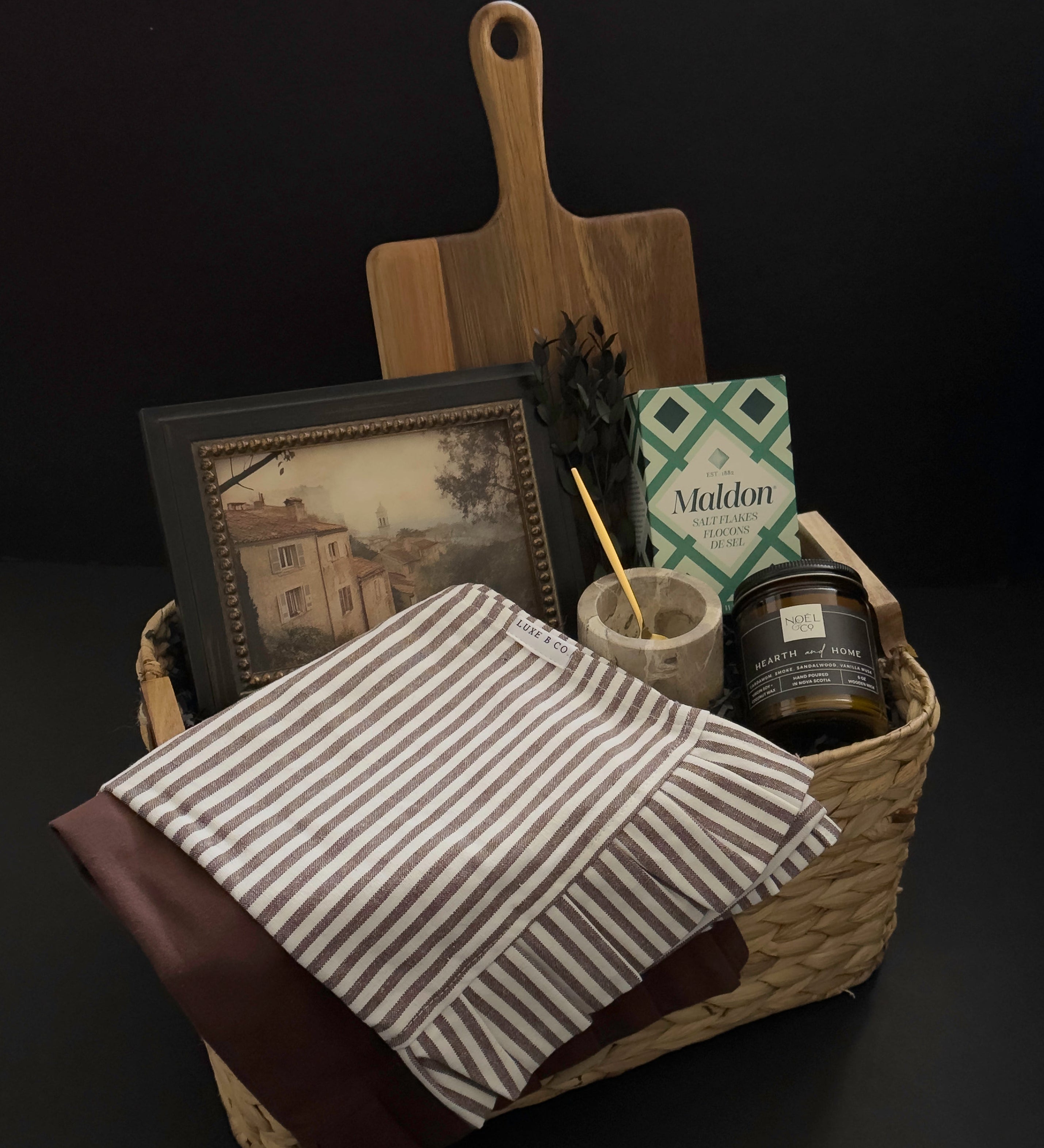 Hearth and Home realtor closing gift basket with acacia wood board, framed European artwork, marble salt cellar, striped kitchen towel and candle by Muse Baskets and Co.