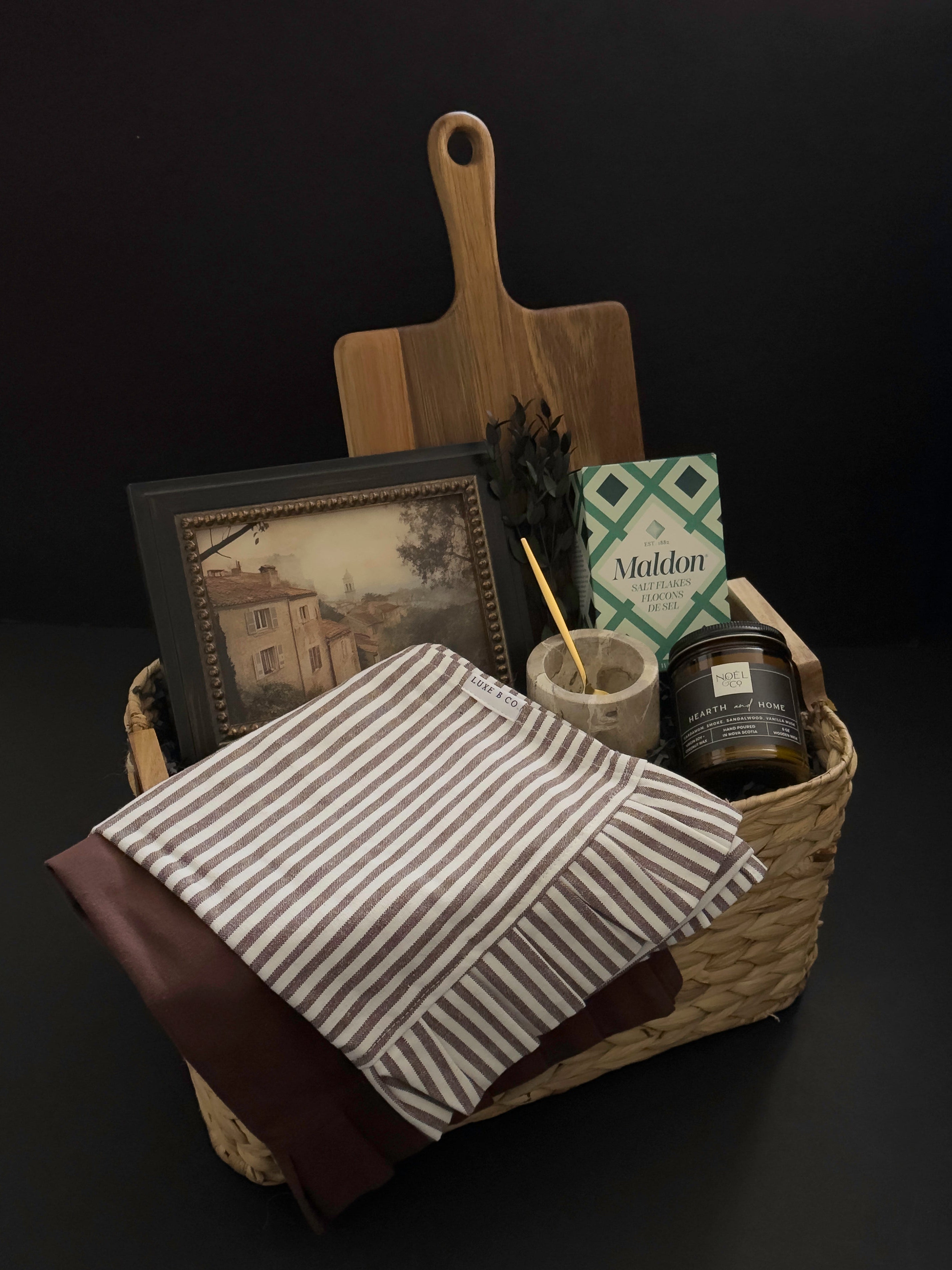 Hearth and Home realtor closing gift basket with acacia wood board, framed European artwork, marble salt cellar, striped kitchen towel and candle by Muse Baskets and Co.