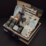 Canadian Gourmet artisan gift box by Muse Baskets and Co., an angled view of a wood crate filled with Canadian small-batch makers including coffee, chocolate bark, French onion jam, and everything bagel cashews, finished with a navy satin ribbon as a homeowner welcome and client appreciation gift.