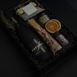 Obsidian Celebration Box with sparkling wine, chocolates, pretzels, honey, and fig spread arranged in a black gift box with festive greenery and ribbon.