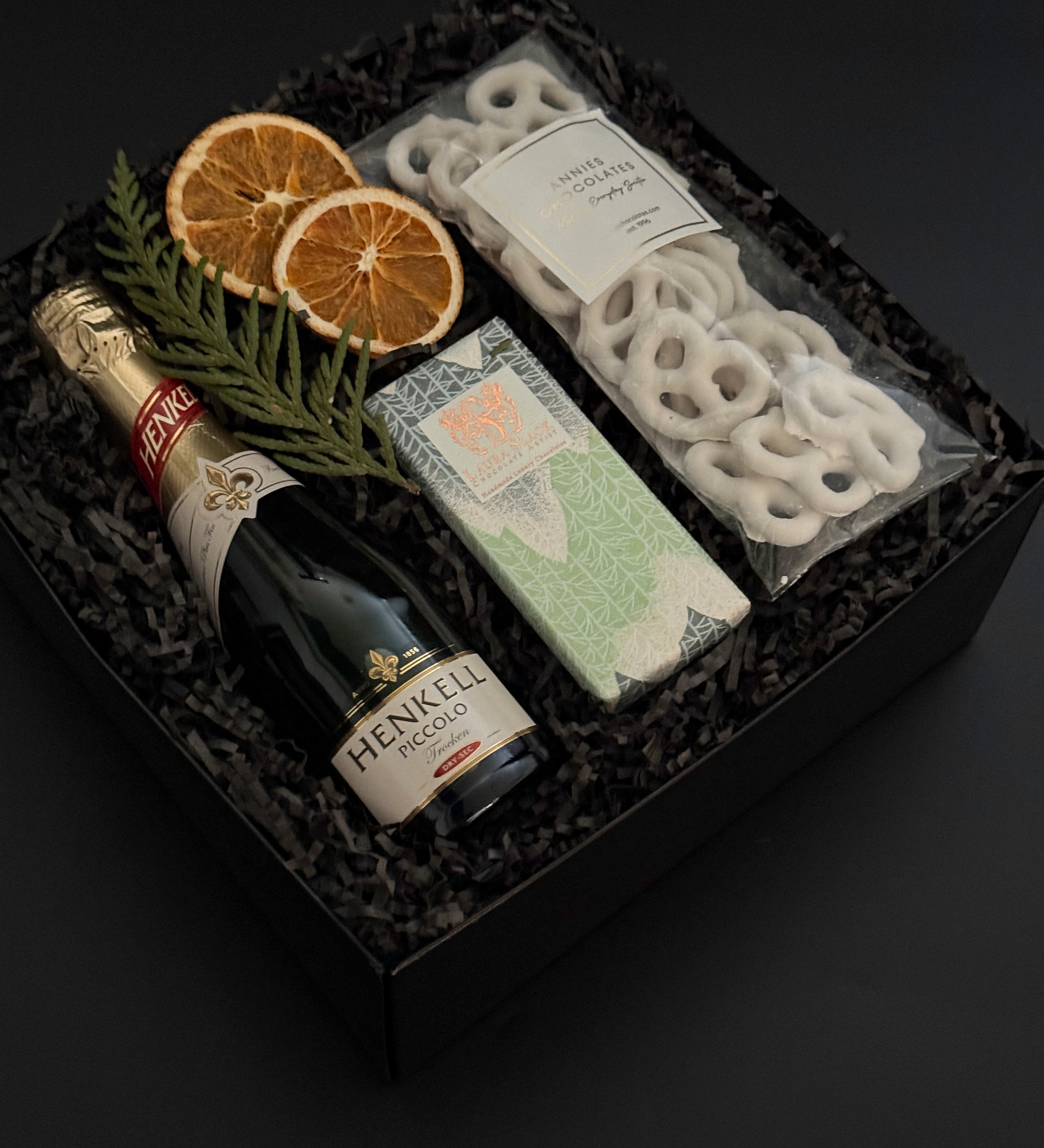 Étoile holiday gift box with sparkling wine, artisan chocolate, pretzels, and festive citrus accents.