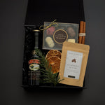 The Parlour Christmas gift box by Muse Baskets and Co. arranged with Baileys, gourmet chocolates, classic hot chocolate, cinnamon sticks and seasonal greenery.