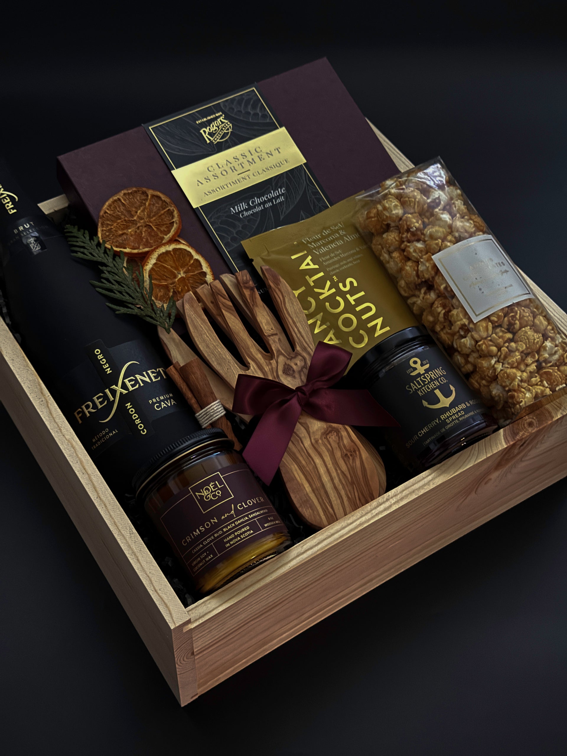 Gift basket with chocolate, nuts, and other confections on a dark background