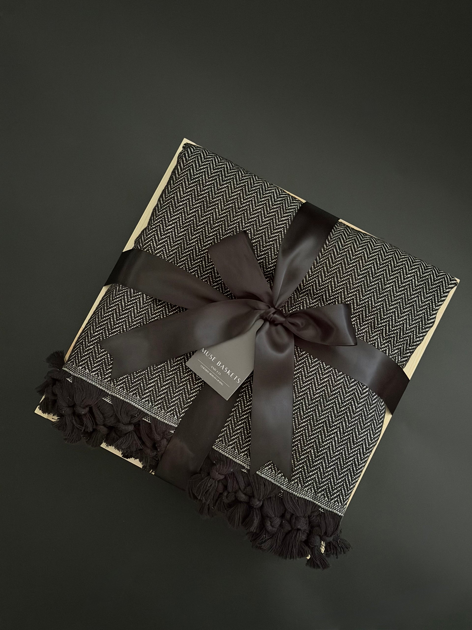 Gift box with a black ribbon on a dark background