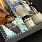 Fireside Provisions corporate holiday gift by Muse Baskets and Co., featuring an acacia board, Winter Wellness Tea and Drizzle honey.